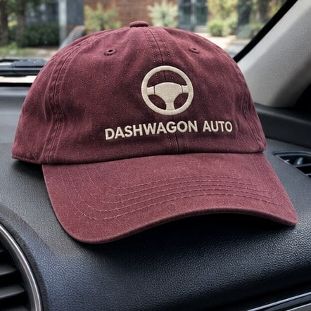 Branded team dad hat on a car dashboard